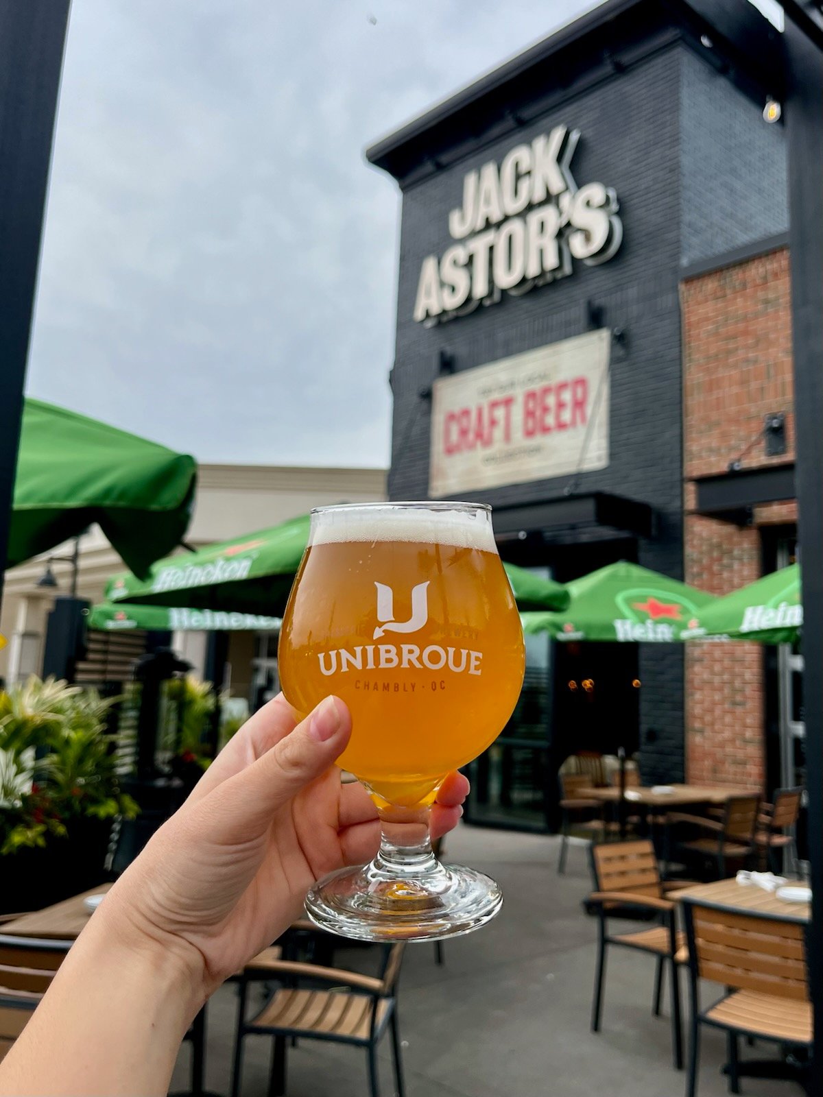 Jack Astors Instagram Post of a hand holding a beer